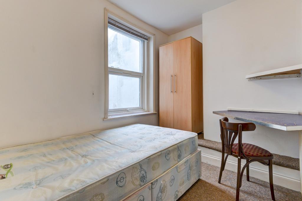Bright single bedroom with a large window, fitt...