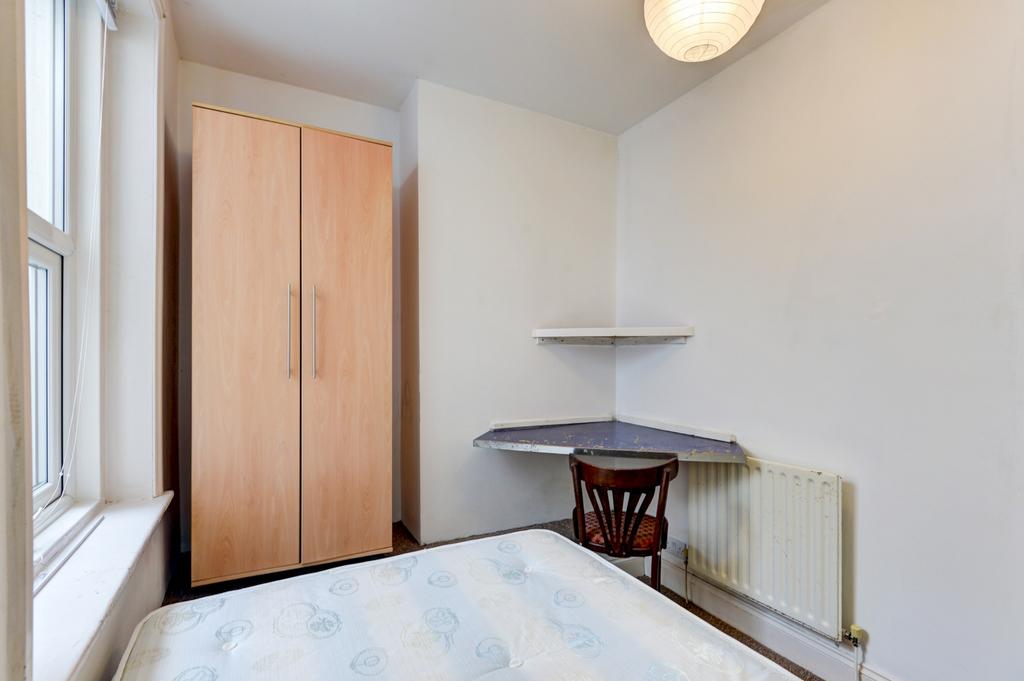 Bright, simply furnished bedroom with a wardrob...