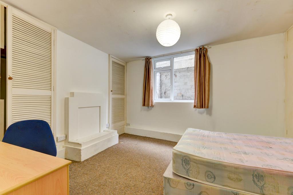 Simple, well-kept bedroom with a window letting...