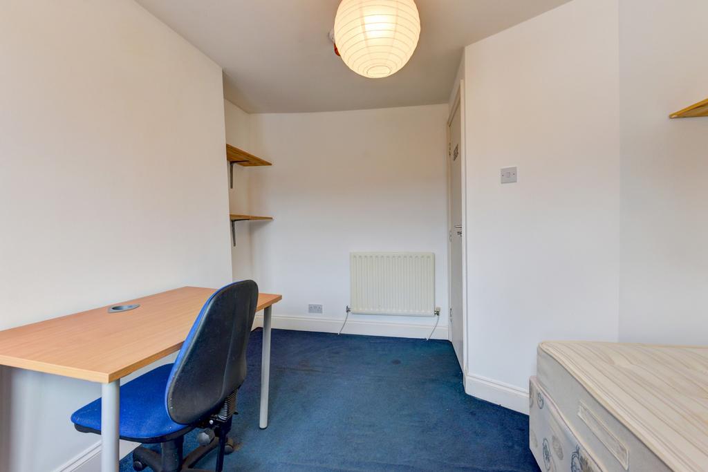 Neat single bedroom with a desk and chair, fitt...