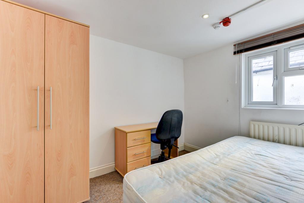Bright, simply furnished bedroom with a double ...