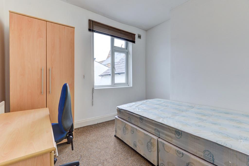 Bright, simply furnished bedroom with a comfort...
