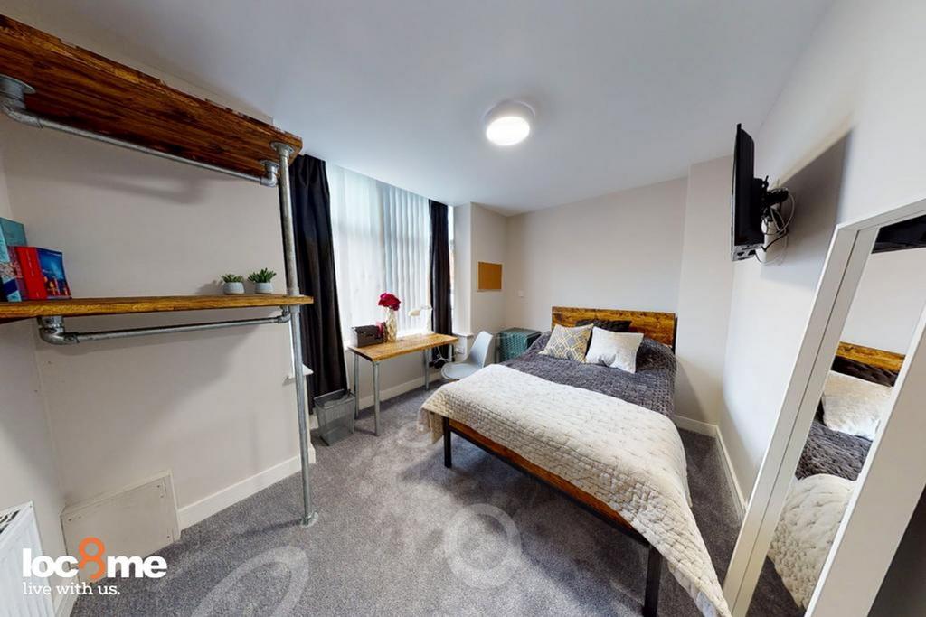 A cozy and well-lit double bedroom featuring mo...