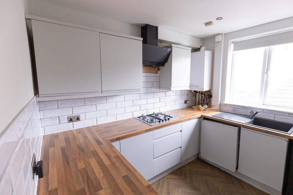 Bright and modern kitchen featuring ample white...