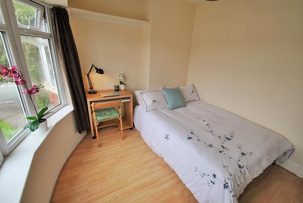 A bright and cozy single bedroom featuring a la...