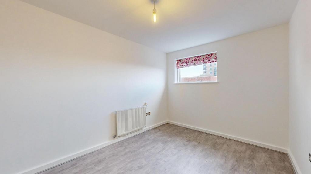 A simple, clean room with light grey flooring, ...