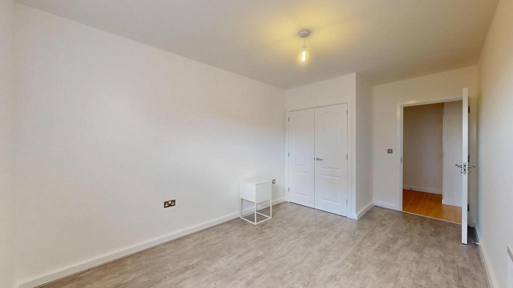 A bright double bedroom featuring a built-in wa...