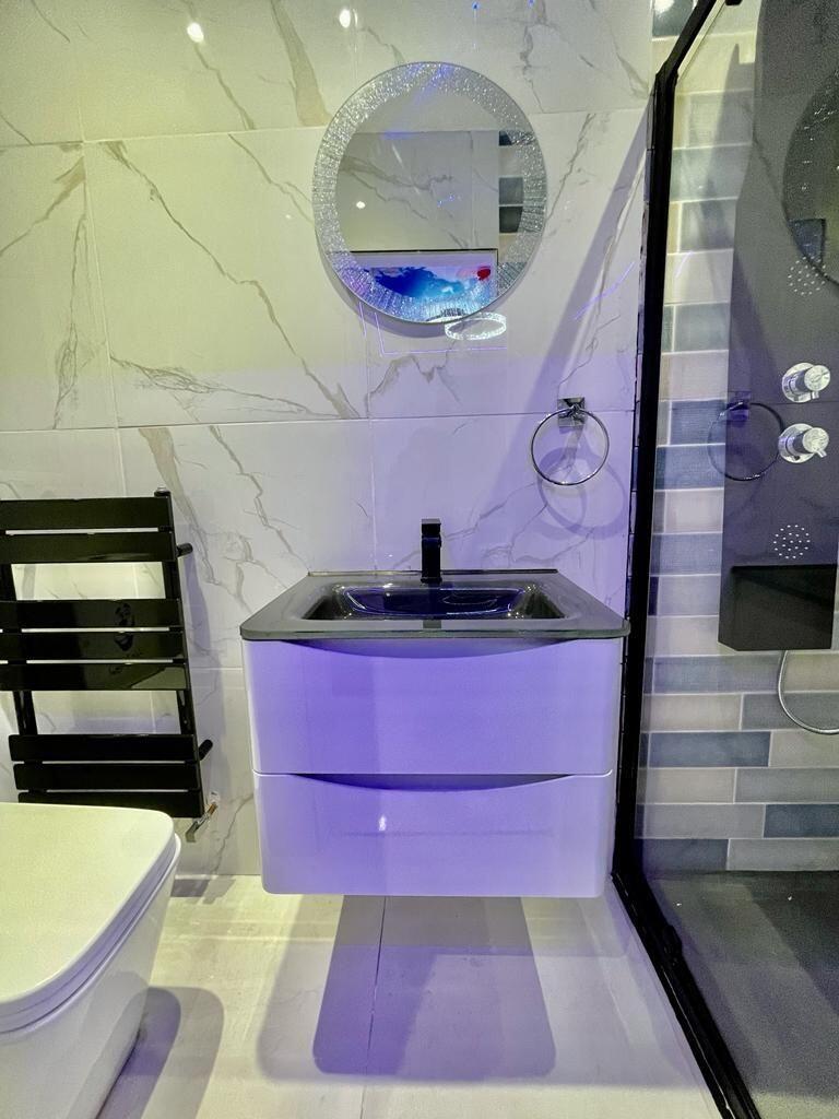 A modern bathroom featuring sleek white marble-...