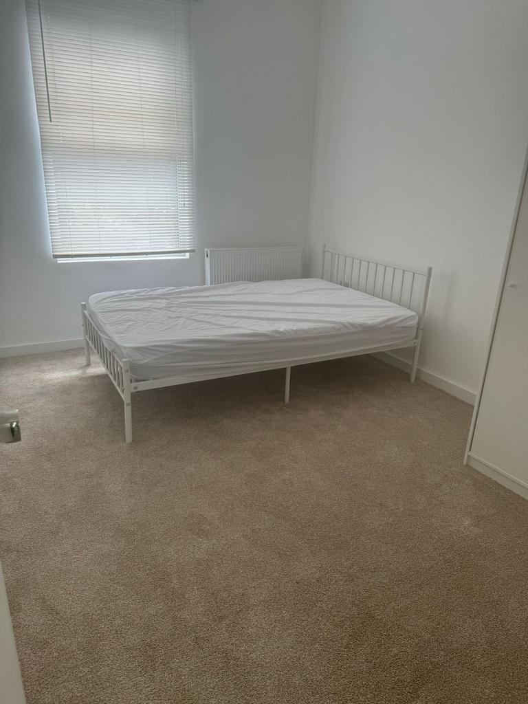 A bright and tidy double bedroom with neutral c...