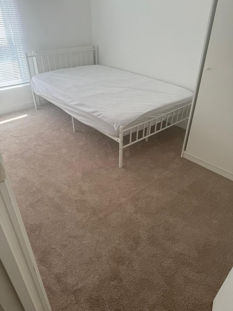 A bright and clean double bedroom featuring a w...