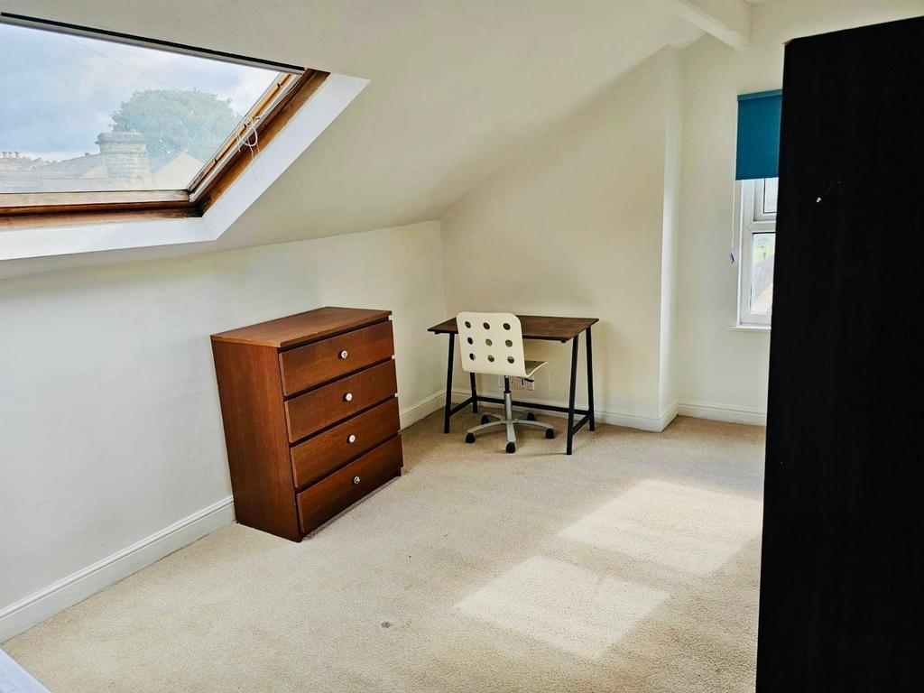 Bright and tidy bedroom featuring a wooden dres...
