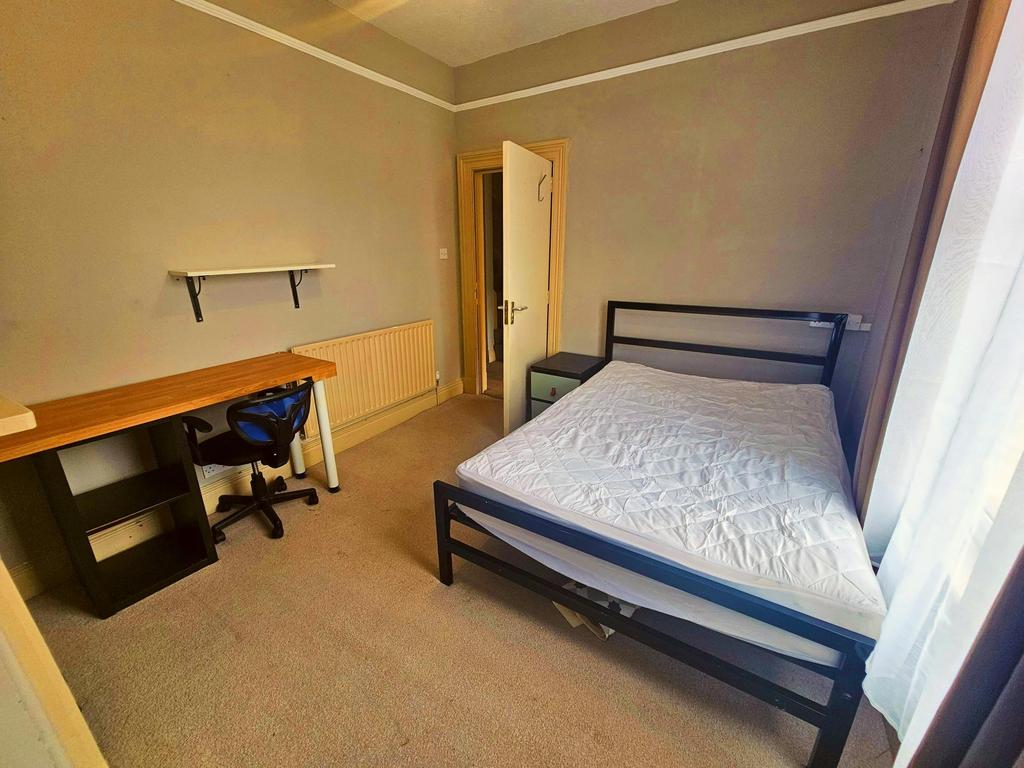 A cozy single bedroom with a neatly made bed an...