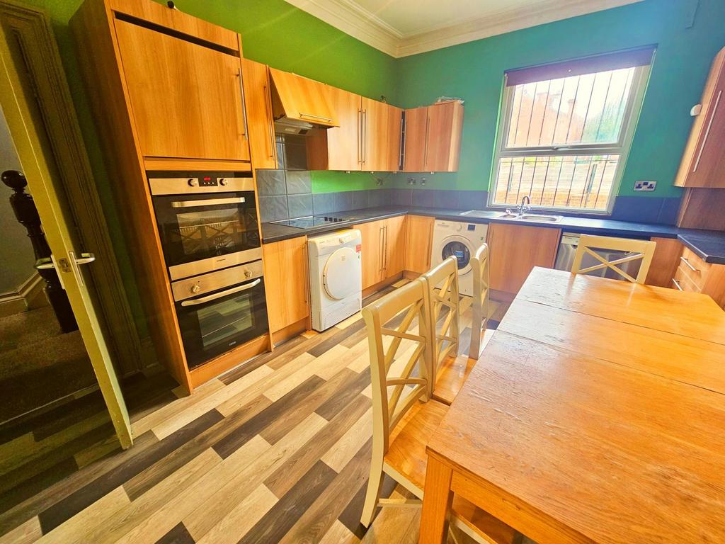 A well-lit and tidy kitchen area featuring wood...