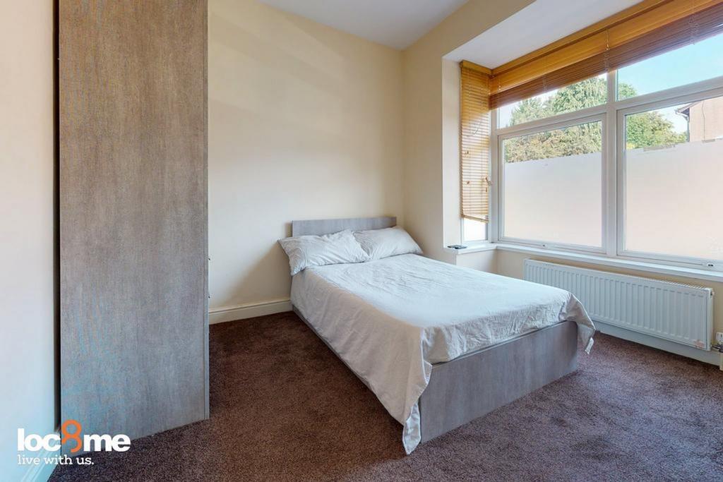 A bright and inviting double bedroom with ample...