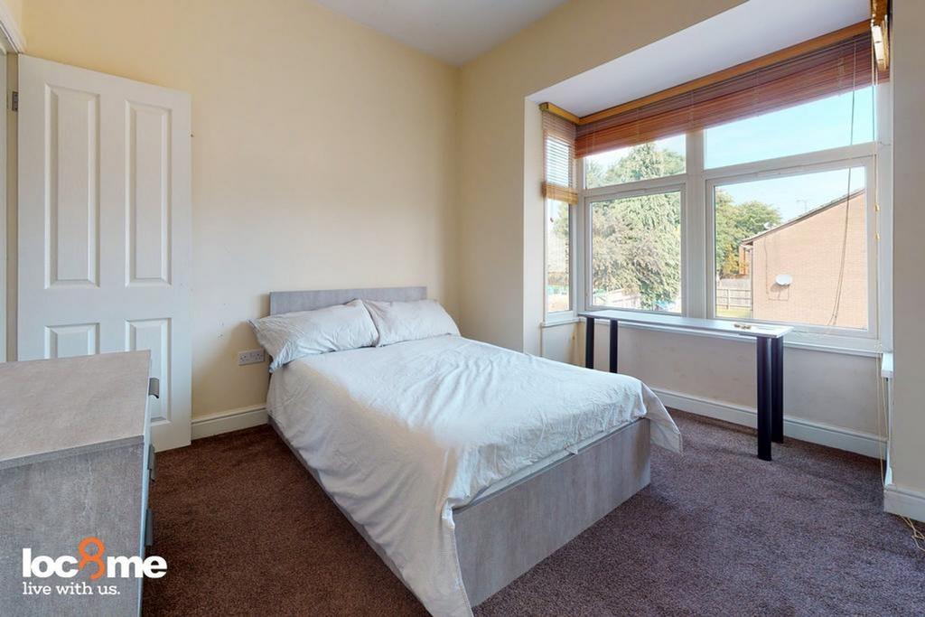 A bright and inviting double bedroom with ample...