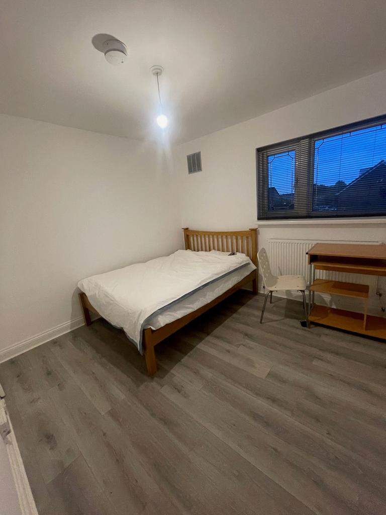 A clean and simple student bedroom featuring a ...