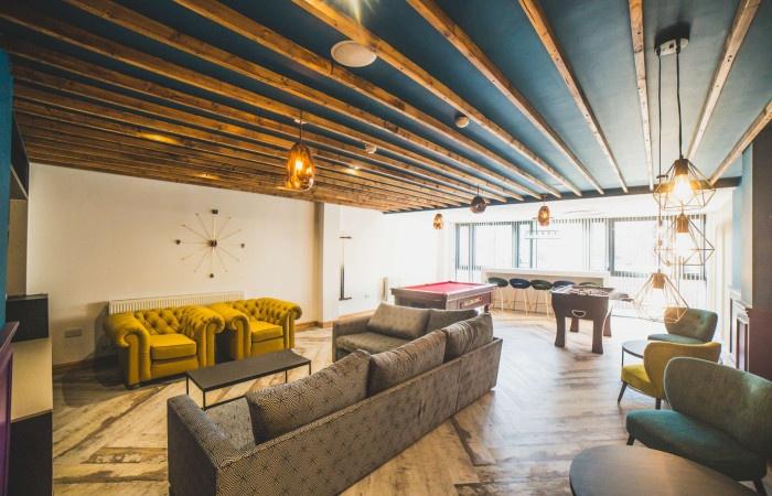 A stylish communal lounge featuring modern pend...