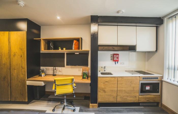 A modern student kitchen area featuring wooden ...