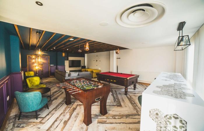 A stylish communal lounge featuring a foosball ...