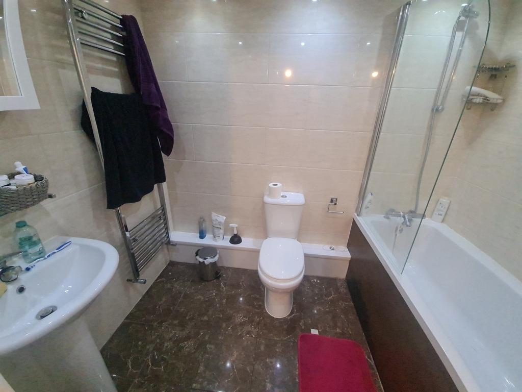 A bright and clean bathroom suite featuring a f...