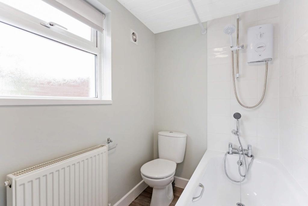 Bright and modern bathroom suite featuring a cl...