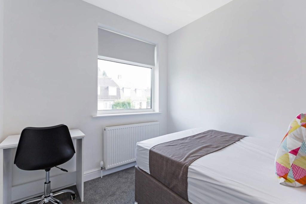 A bright and tidy single bedroom featuring a co...