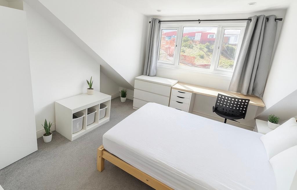 Bright, modern double bedroom with a large wind...