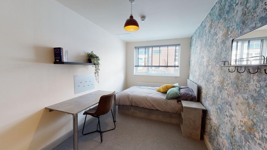 A cozy, well-lit bedroom featuring a comfortabl...