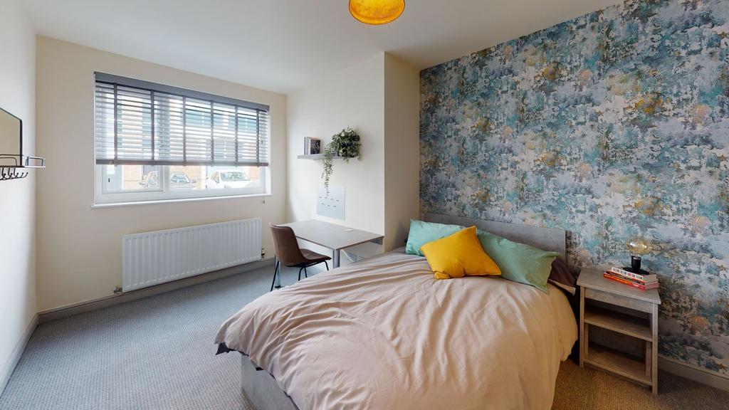 Bright and modern bedroom featuring a large win...