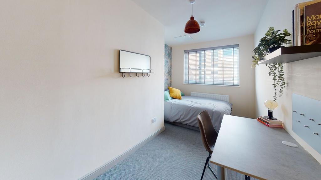 Bright and cozy bedroom featuring a comfortable...