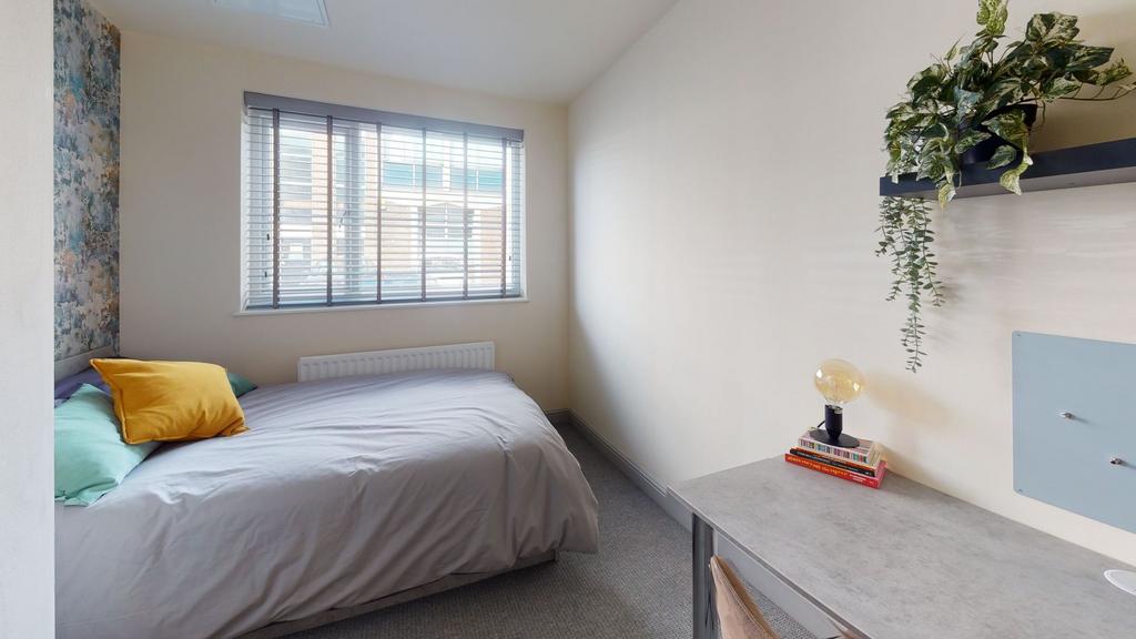 A bright and cozy single bedroom with a large w...