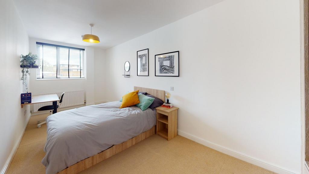 A bright and welcoming master bedroom with a la...