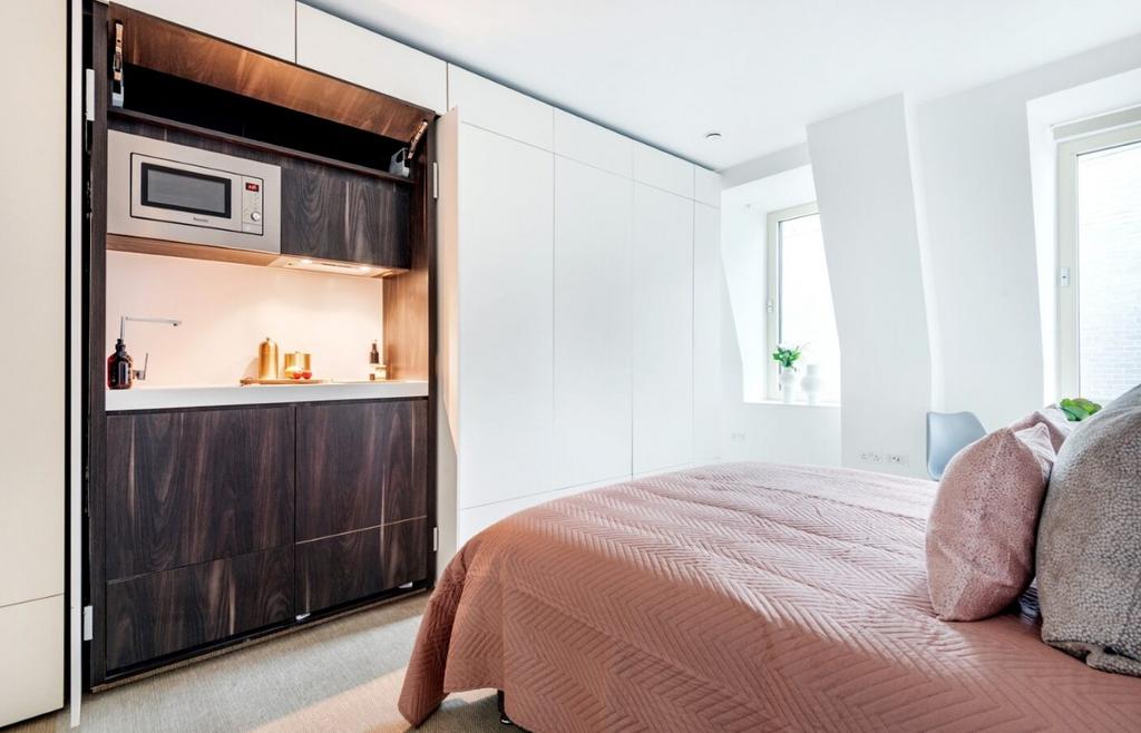 A clean and well-lit double bedroom featuring a...