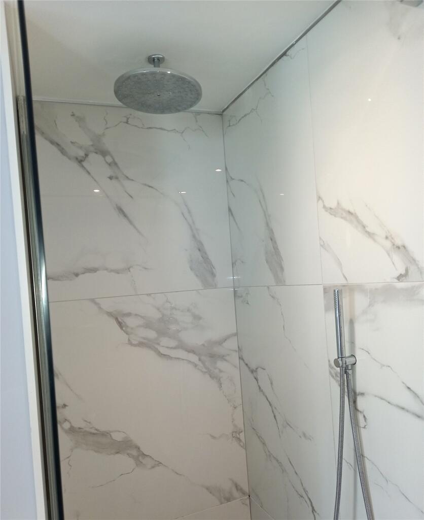 A modern bathroom shower area featuring elegant...