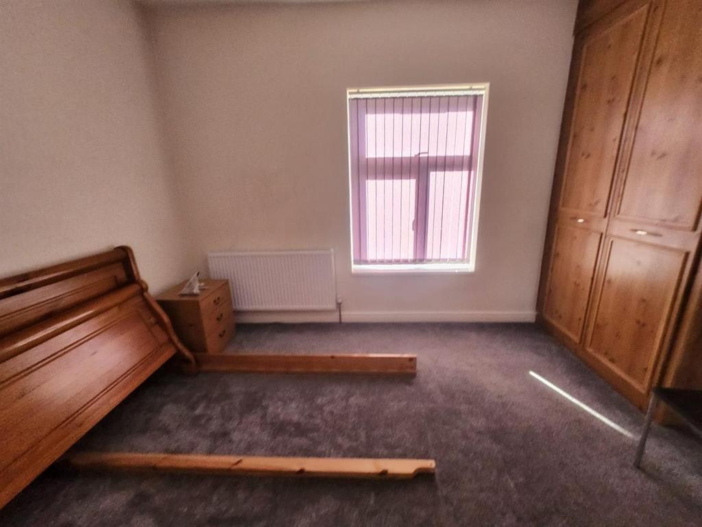 A tidy bedroom with a window providing natural ...