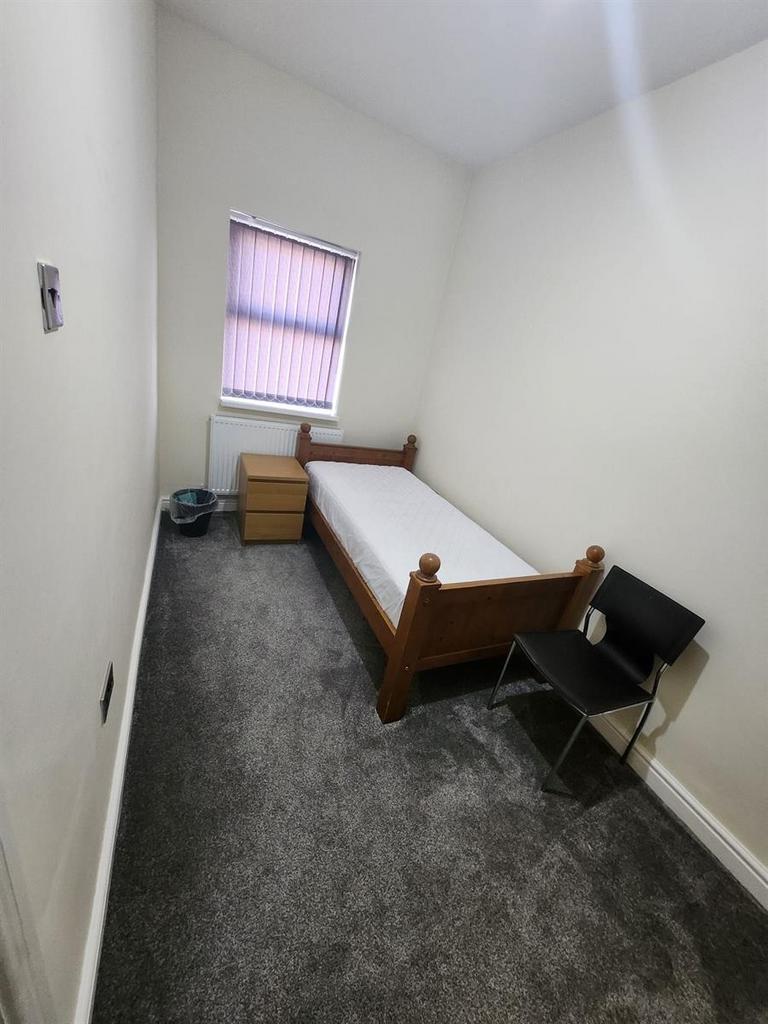 A clean and simple single bedroom featuring a w...