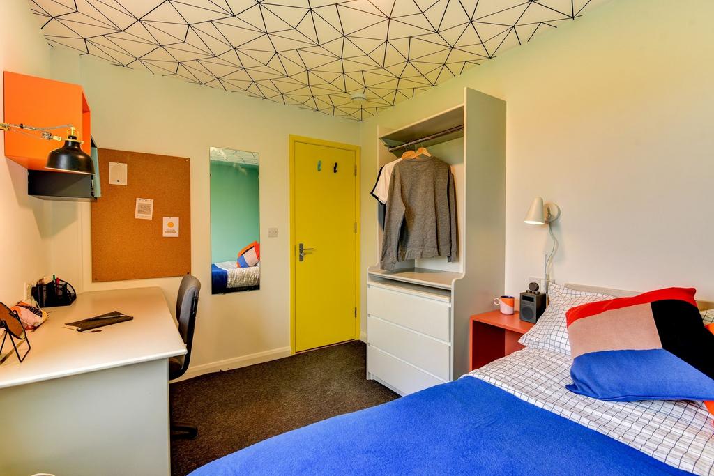 A cozy and well-kept single bedroom featuring a...