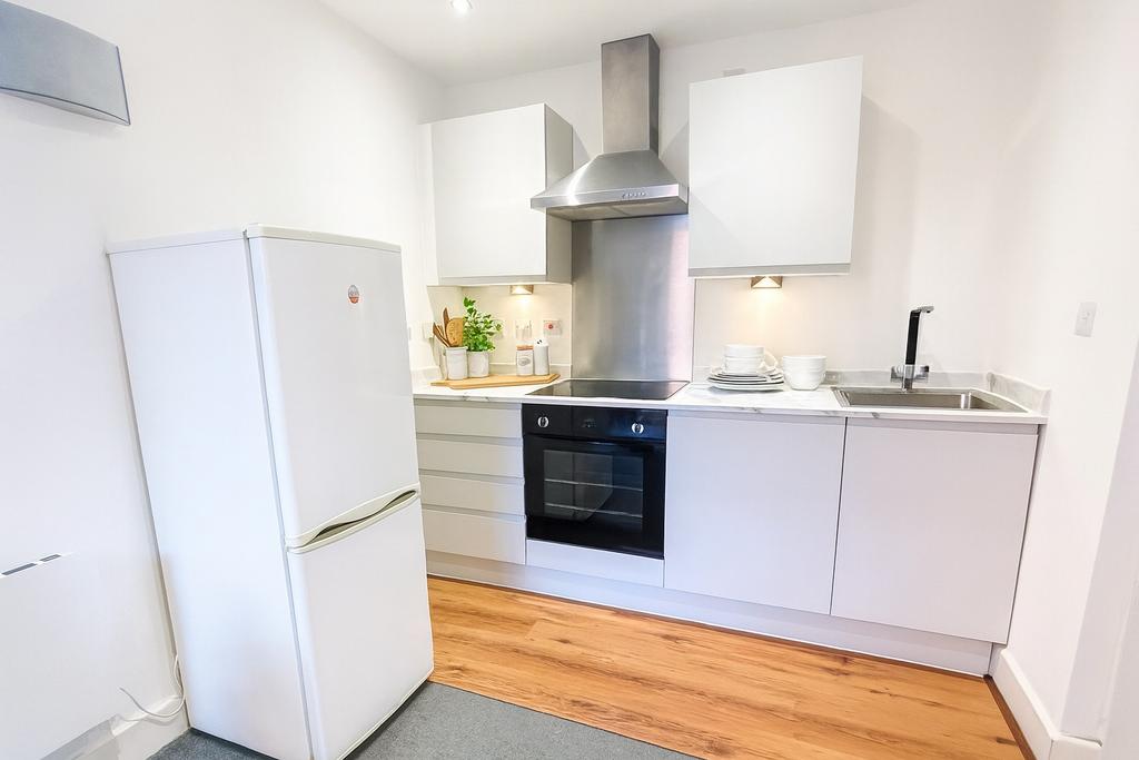 A bright and clean kitchen featuring modern whi...