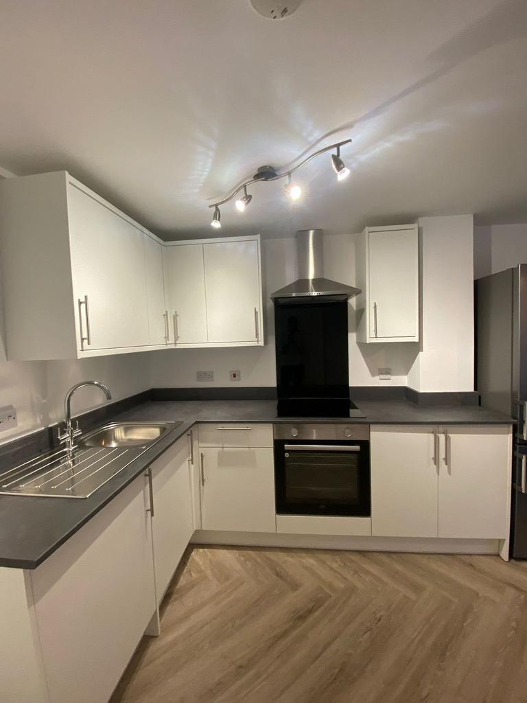 Modern, clean kitchen with white cabinetry, sta...