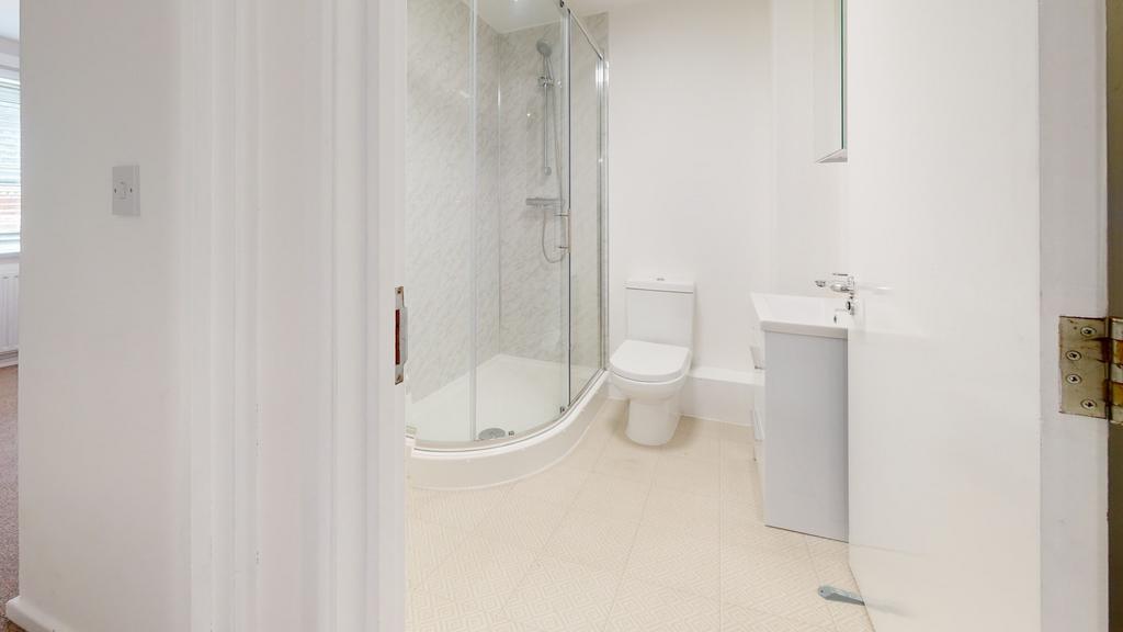 Bright and clean bathroom featuring a shower wi...