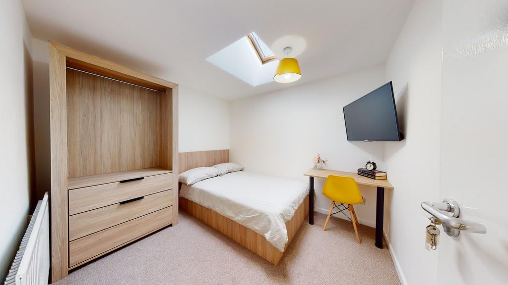 A well-lit, cozy double bedroom with a large wi...