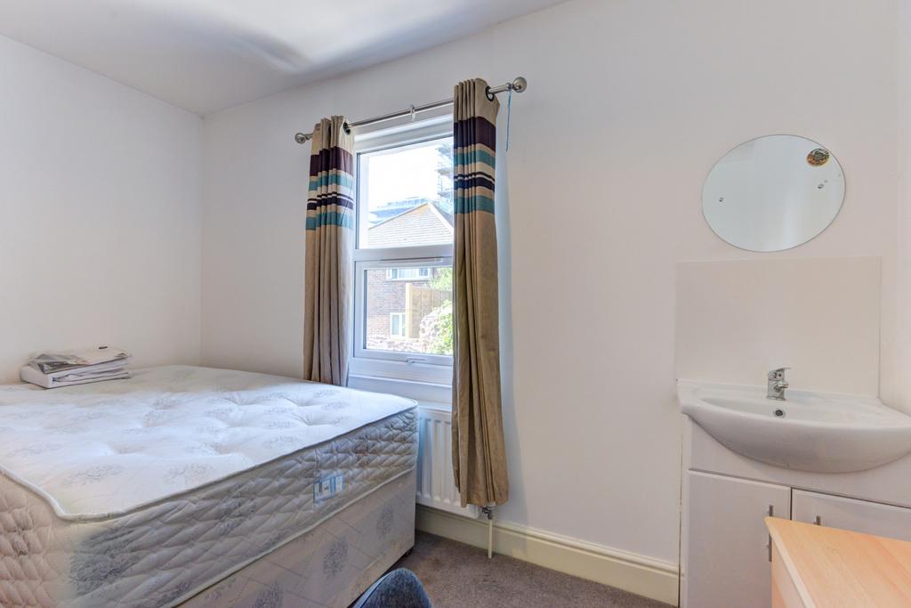 A simple and tidy bedroom featuring a single be...