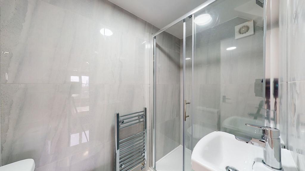 Modern bathroom with a glass shower enclosure a...