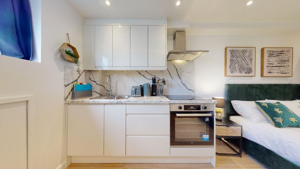A modern studio space featuring a sleek white k...