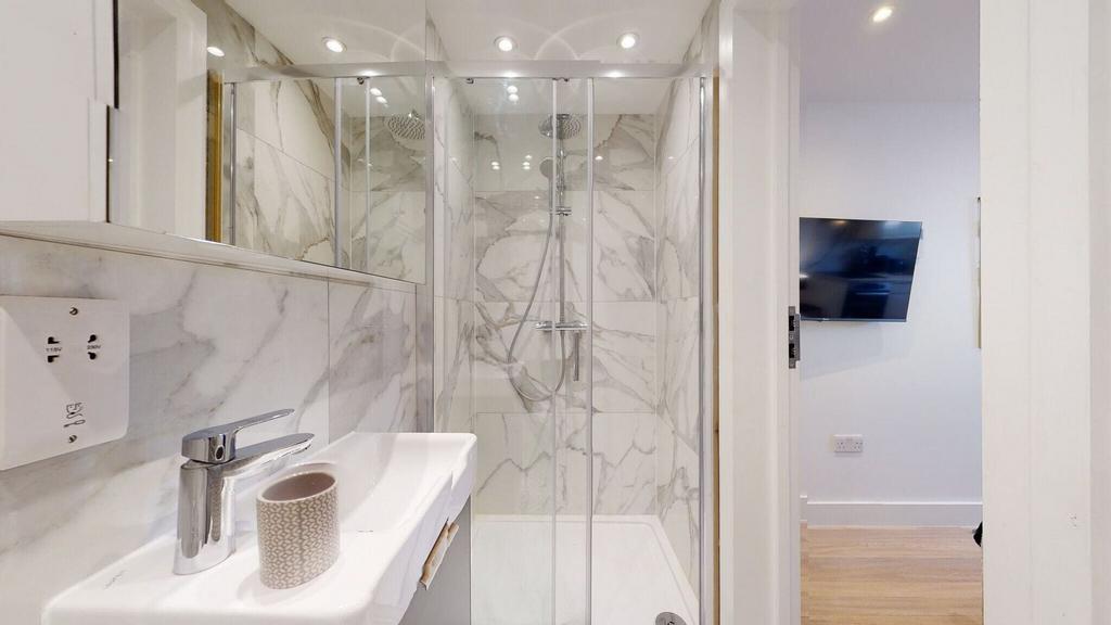 A modern bathroom featuring stylish marble-effe...