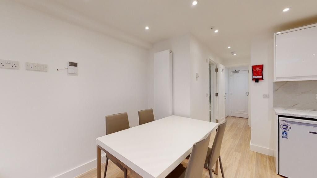 A modern kitchen dining area with a clean white...