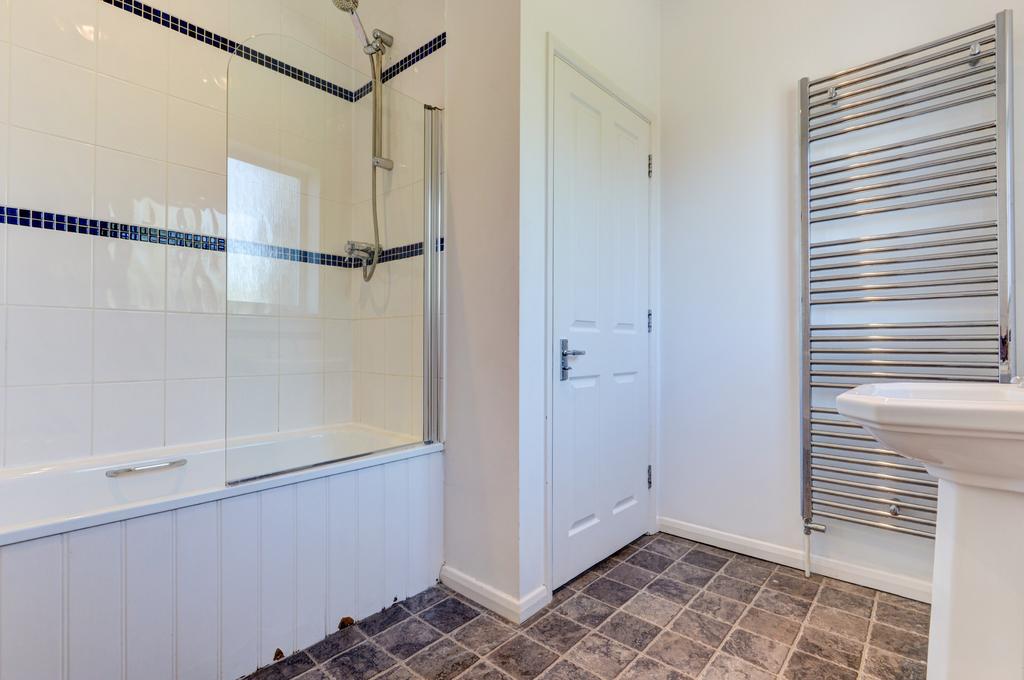 Bright and clean bathroom suite featuring a mod...