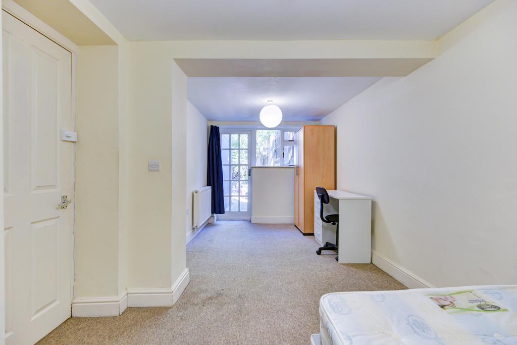 A bright and clean single bedroom featuring a w...