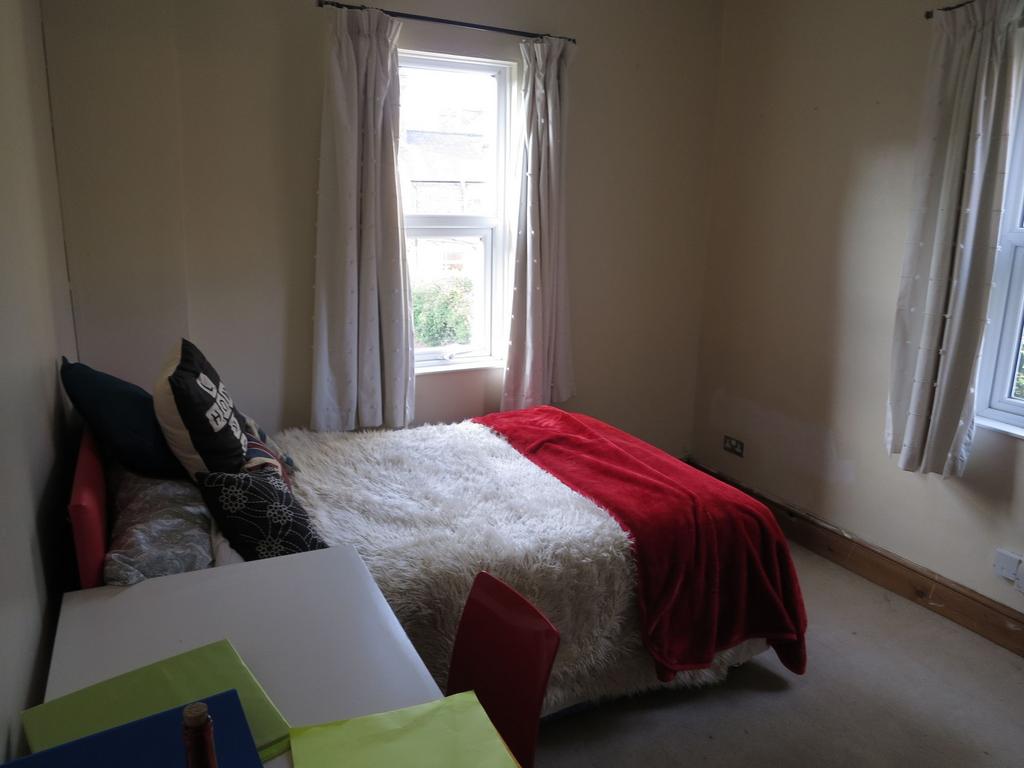 A cozy bedroom featuring a double bed adorned w...
