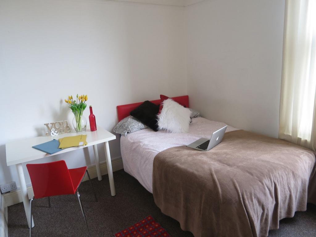 A cozy double bedroom featuring a bed with pill...